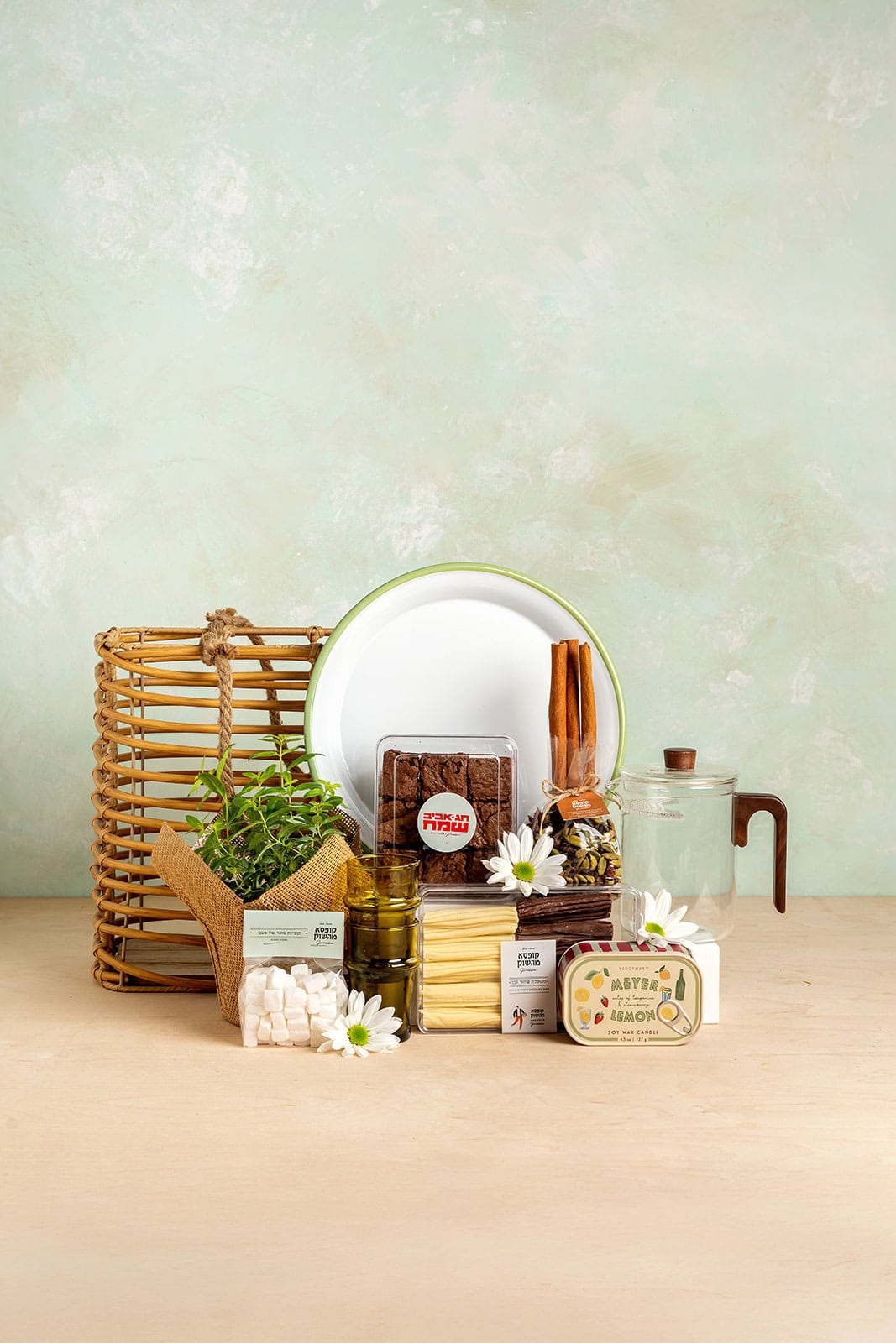 מארז פסח "החיים הטובים" של קופסא מהשוק הכולל מגש אמייל לבן עם שוליים ירוקים, קומקום תה מזכוכית, עציץ תבלין רענן, בראוניז חגיגיים, נר ריחני ומבחר פינוקים למטבח ולאירוח.